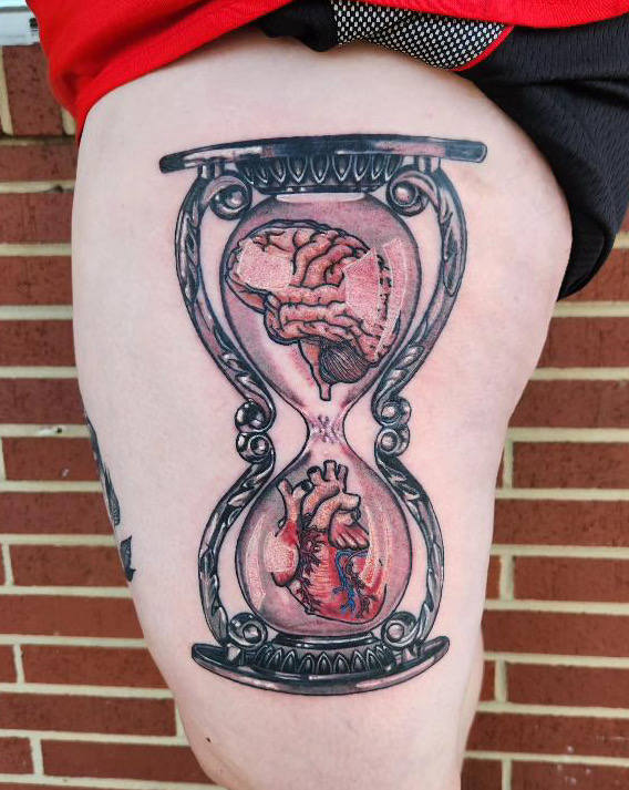 Tattoo an hourglass with a brain and heart by tattoo artist Britney Farmer of Sacred Mandala Studio.